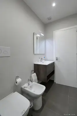 a white bathroom with a toilet and a sink at Maison Cutò in Palermo