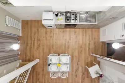 a kitchen with white appliances and wooden floors at Maison Cutò in Palermo