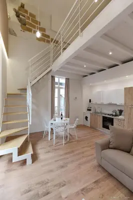 a living room with a table and a staircase at Maison Cutò in Palermo