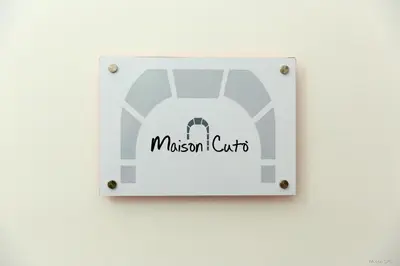 a sign for a museum cut out on a wall at Maison Cutò in Palermo