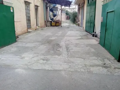 an empty alley with green doors in a building at Apartments Bed Abate in Villabate