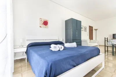 a bedroom with a blue bed with towels on it at Apartments Bed Abate in Villabate