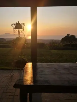 a bench in front of a window with the sunset at Ziba Villa Siciliana con piscina e vista panoramica sul mare in Borgetto