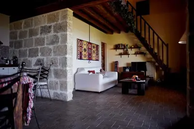 a living room with a white couch and a stone wall at Ziba Villa Siciliana con piscina e vista panoramica sul mare in Borgetto