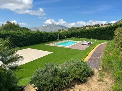 a garden with a swimming pool in the middle of it at Ziba Villa Siciliana con piscina e vista panoramica sul mare in Borgetto