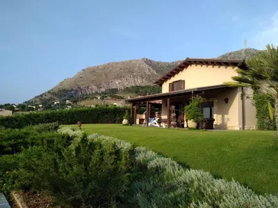 a house with a mountain in the background at Ziba Villa Siciliana con piscina e vista panoramica sul mare in Borgetto