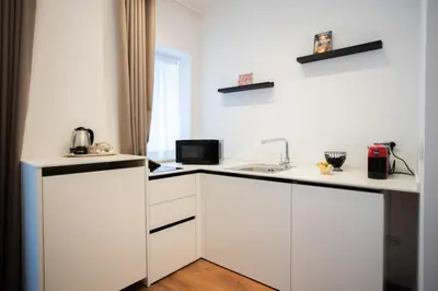 a kitchen with white cabinets and a sink at Palazzo del Poeta - Dimora Contemporanea in Palermo