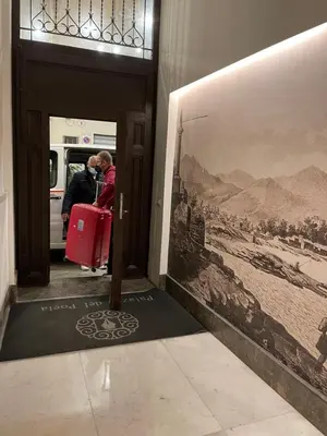 a person taking a picture of a train with a red suitcase at Palazzo del Poeta - Dimora Contemporanea in Palermo