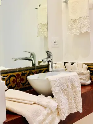 a bathroom with a sink and towels on a counter at Palazzo del Poeta - Dimora Contemporanea in Palermo