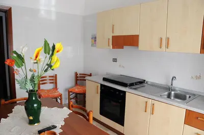 a kitchen with a table with a vase of flowers at Katia appartamenti in San Vito lo Capo