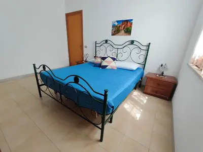 a bedroom with a bed with a blue comforter at Katia appartamenti in San Vito lo Capo