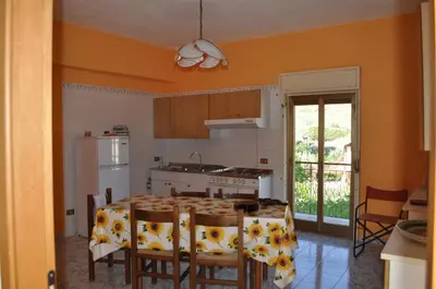 a kitchen with a table with chairs and a refrigerator at Summerhouse Sagana in Monreale