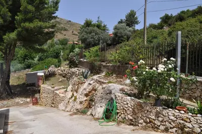 a garden with flowers and a stone wall at Summerhouse Sagana in Monreale