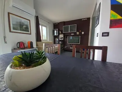 a dining room with a table with a plant on it at Casa sul mare in Isola delle Femmine