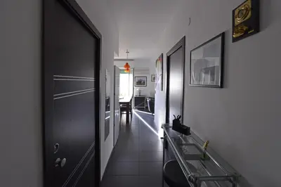 a hallway with a black door and a dining room at Casa sul mare in Isola delle Femmine