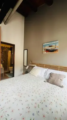 a bedroom with a bed and a painting on the wall at Kasa Kala Rooms & Apartments in Palermo