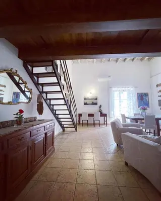 a large living room with a staircase and a table at Kasa Kala Rooms & Apartments in Palermo