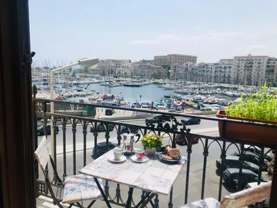 a balcony with a table and a view of a marina at Kasa Kala Rooms & Apartments in Palermo