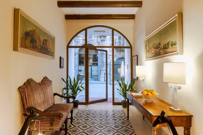 a living room with a table and a chair at Palazzo Arone dei Baroni di Valentino in Palermo