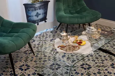 a room with two green chairs and a table with a tray of food at Palazzo Arone dei Baroni di Valentino in Palermo