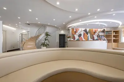 a lobby with a staircase in a building at Alaba Hotel in San Vito lo Capo