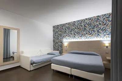 a hotel room with two beds and a mirror at Alaba Hotel in San Vito lo Capo