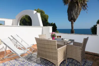 a patio with chairs and a table with a view of the ocean at Villa Mallandrino in Mondello