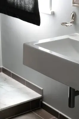 a white bathroom with a sink and a staircase at B&B Le Biciclette in San Vito lo Capo