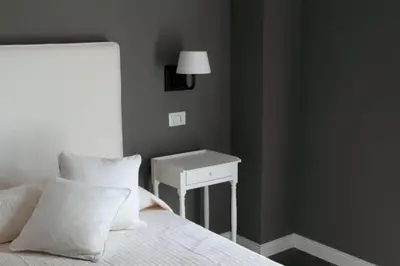 a bedroom with a bed with a table and a lamp at B&B Le Biciclette in San Vito lo Capo