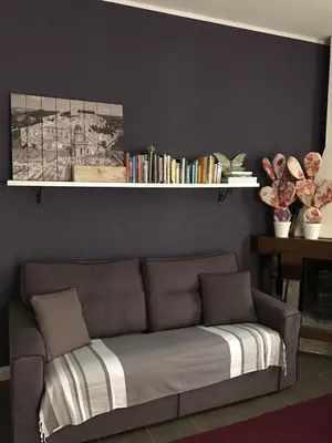 a couch in a living room with a shelf with books at B&B Le Biciclette in San Vito lo Capo