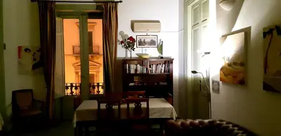a living room with a table and a window at Cavour Il Conte Camillo in Palermo