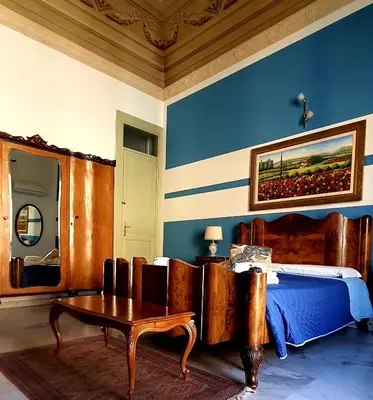 a bedroom with a bed and a table in a room at Cavour Il Conte Camillo in Palermo