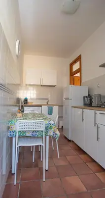 a kitchen with a table and a kitchen with white cabinets at Casa BabbaLuciana in Mondello