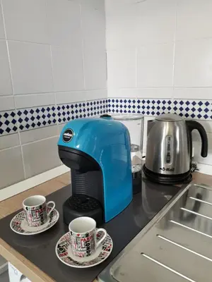 a blue toaster sitting on a kitchen counter with two cups at Casa BabbaLuciana in Mondello