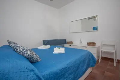 a bedroom with a blue bed with towels on it at Casa BabbaLuciana in Mondello