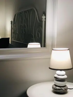 a lamp sitting on a table in front of a mirror at B&B Opera dei Pupi in Palermo