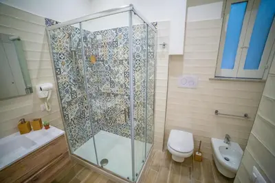 a bathroom with a shower and a toilet and a sink at B&B Opera dei Pupi in Palermo