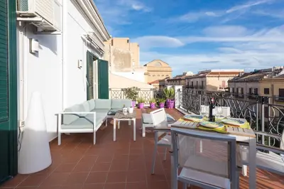 a balcony with a table and chairs on a building at Central Apartment with terrace near teatro Massimo in Palermo