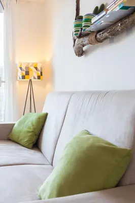 a white couch with green pillows in a room at Central Apartment with terrace near teatro Massimo in Palermo