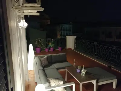 a couch and a table on a balcony at night at Central Apartment with terrace near teatro Massimo in Palermo