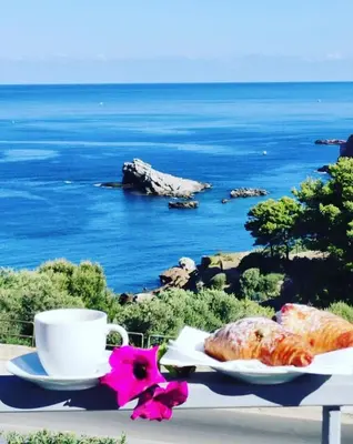 a table with a cup of coffee and a plate of food at Zabbàra B&B in Terrasini
