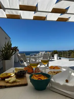 a table with glasses of wine and food on it at Zabbàra B&B in Terrasini