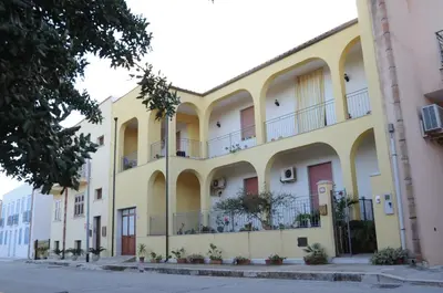 a large yellow building with balconies on a street at case vacanze Rosy in San Vito lo Capo