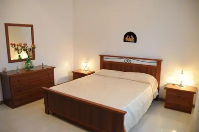 a bedroom with a bed and two dressers and a mirror at case vacanze Rosy in San Vito lo Capo