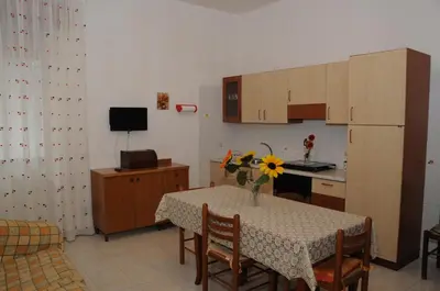 a kitchen with a table with a vase of flowers on it at case vacanze Rosy in San Vito lo Capo