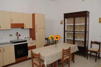 a kitchen with a table with a vase of flowers on it at case vacanze Rosy in San Vito lo Capo