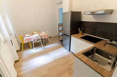 a kitchen with a sink and a table with chairs at Central Coa Apartment in Palermo