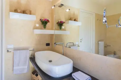 a bathroom with a sink and a large mirror at Villa Gabriella - Mondello in Mondello