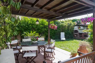 a patio with a table and chairs under a pergola at Villa Gabriella - Mondello in Mondello
