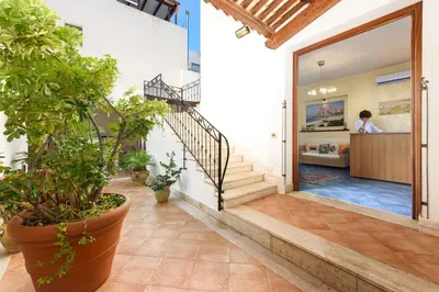 a hallway of a house with potted plants at La Meridiana Hotel in San Vito lo Capo